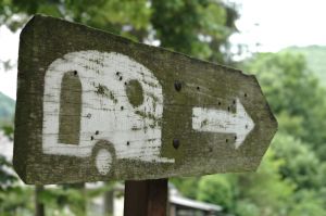 picture of a wooden sign with a picture of a caravan painted on it